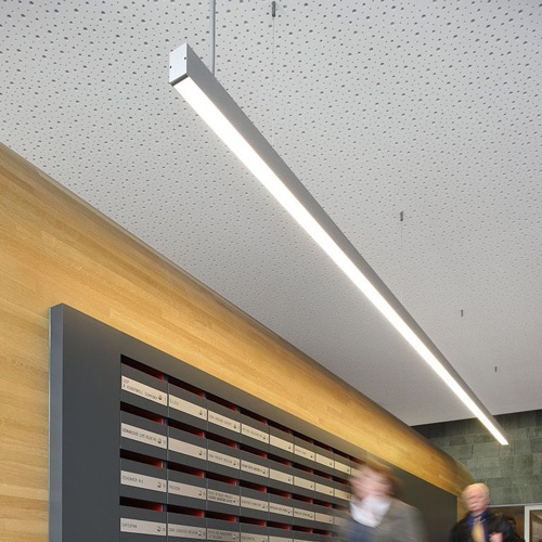 two blurred women walking underneath a linear light